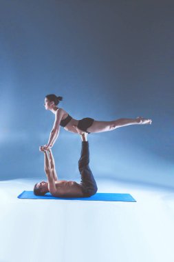 Genç çift Acro yoga mat Studio birlikte uygulamak. Acroyoga. Çift yoga. Ortak yoga.