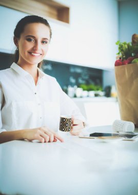 Giderleri planlama ve mutfağını faturalarında ödeme genç kadın.