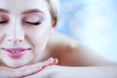 Masaj masasında uzanmış gözleri kapalı rahatlayan genç bir kadın. - Kadın. Spa salonu