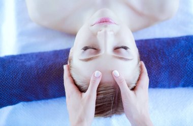 Masaj masasında uzanmış gözleri kapalı rahatlayan genç bir kadın. - Kadın. Spa salonu