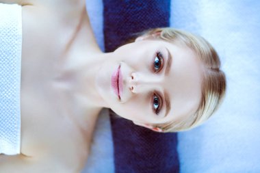 Bir masaj masanın üzerinde yatan, rahatlatıcı bir genç kadın. Kadın. Spa Salonu