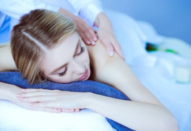 Masaj masasında uzanmış gözleri kapalı rahatlayan genç bir kadın. - Kadın. Spa salonu