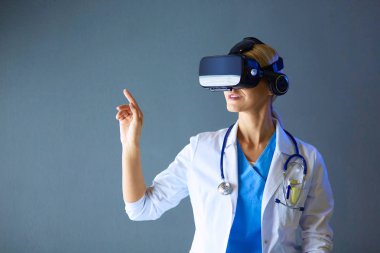 Sanal gerçeklik gözlüğü takan kadın doktor beyaz arka planda izole edilmiş..