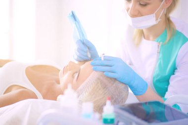 Kaşlar için kalıcı makyaj. Güzellik salonunda kalın kaşlı güzel bir kadın..