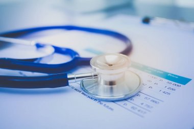 Tıbbi ekipman: Beyaz arka planda mavi steteskop ve tablet. Tıbbi ekipman