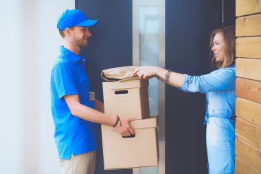 Mavi üniformalı gülümseyen kurye servis konseptine paket kutusu teslim eden teslimatçı. Mavi üniformalı gülümseyen teslimatçı.