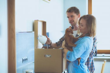 Genç bir çift yeni evde büyük karton kutu taşıyan. Ev taşıma. Genç Çift