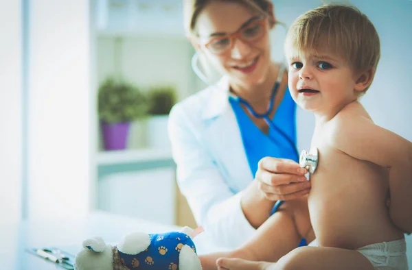 Ženský doktor poslouchá dítě se stetoskopem na klinice — Stock fotografie