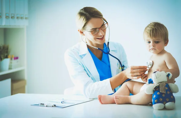 Female doctor is listening kid with a stethoscope in clinic — Stock Photo, Image