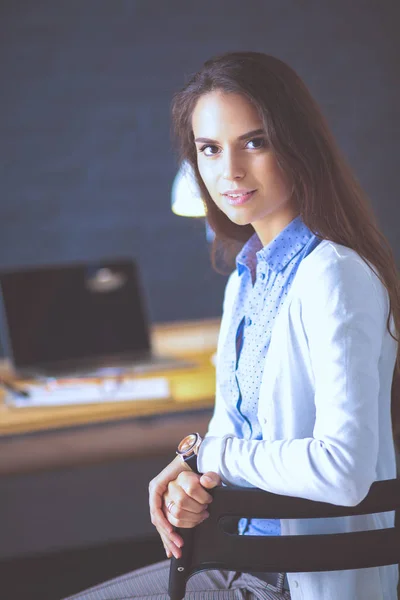 Jonge vrouw werkend zittend aan een bureau. — Stockfoto