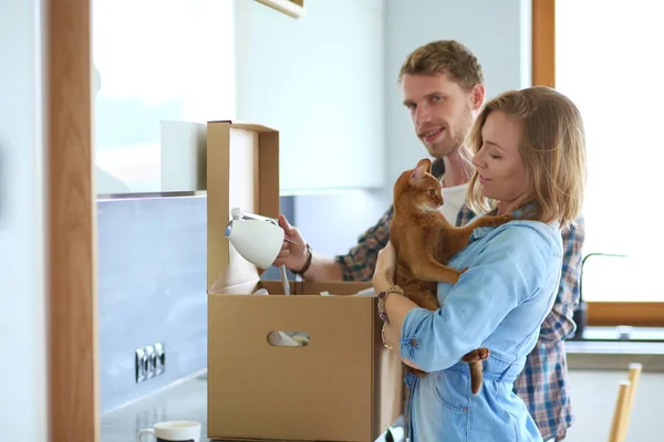 Genç bir çift yeni evde büyük karton kutu taşıyan. Ev taşıma. Genç Çift — Stok fotoğraf