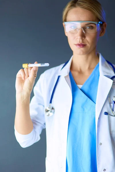 Female medical or research scientist or doctor using looking at a test tube of clear solution in a lab or laboratory. — Stock Photo, Image