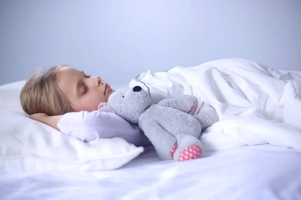 Niño niña duerme en la cama con un osito de peluche de juguete . —  Fotos de Stock