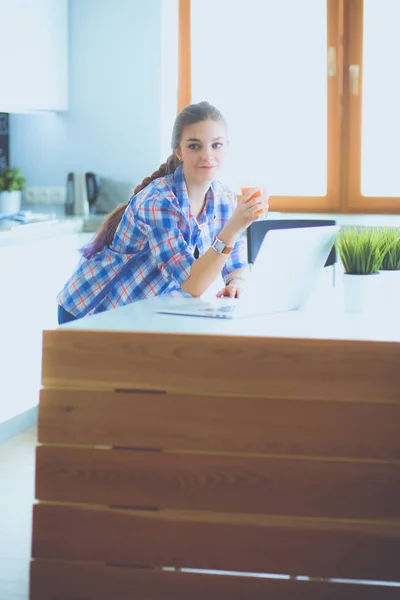 Beautiful young smiling female doctor sitting at the desk and writing. — Stock Photo, Image