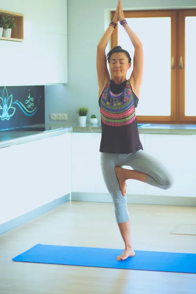 Retrato de una mujer sonriente de yoga sentada en la esterilla de yoga después del entrenamiento en el estudio de yoga. Yoga. Mujer. . — Foto de Stock