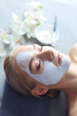 Yüz maskesi. Güzel genç kız Spa, makyajcısı kadın yüz maskesi uygulama.