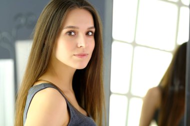 Genç kadın kendini evde aynada yansıma arıyor