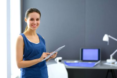 Ev ofisinde tablet üzerinde çalışan çekici bir kadın.