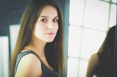 Genç kadın kendini evde aynada yansıma arıyor