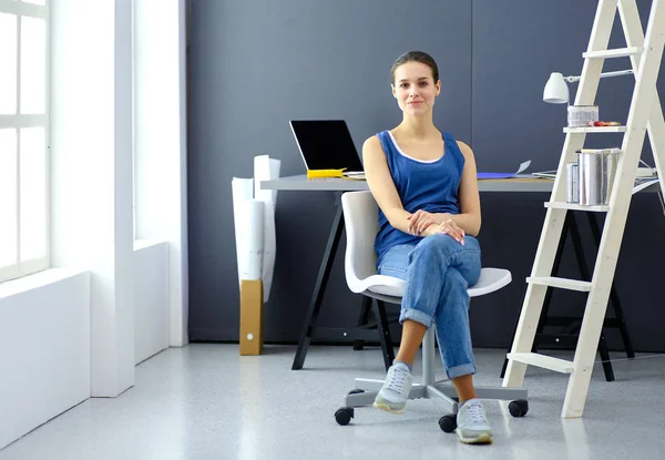 Ung kvinde sidder på skrivebordet på kontoret - Stock-foto