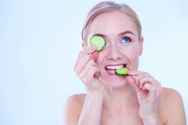 Young beautiful woman with cucumber slices on white background. — Stock Photo, Image