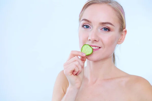 Young beautiful woman with cucumber slices on white background. — Stock Photo, Image