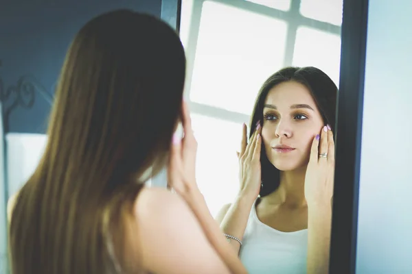 自宅の鏡で自分の反射を探している若い女性 — ストック写真