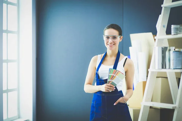 Молодая женщина держит цветные образцы с живописной картиной — стоковое фото