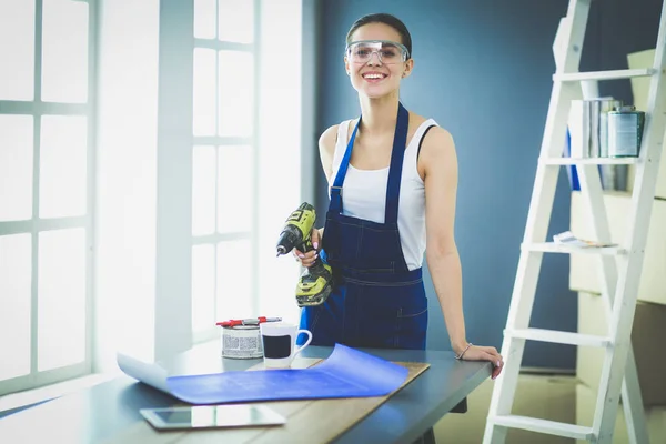 Worker woman with drill standing in new home — Stock Photo, Image