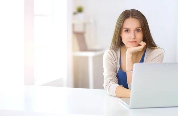 在书桌上使用膝上型电脑的美丽的年轻妇女 — 图库照片