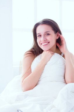 Güzel bir kadın yatağında uzanıyor.