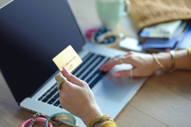 Genç bir kadın kahve molasında ya da kahve molasında dizüstü bilgisayar kullanıyor..