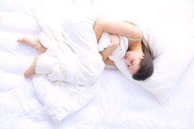 Güzel bir kadın yatağında uzanıyor.