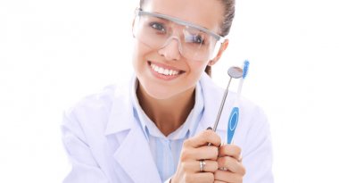 Güzel bir dişçi kadın doktor beyaz arka planda izole edilmiş diş fırçasını tutuyor. Dişçi doktor.