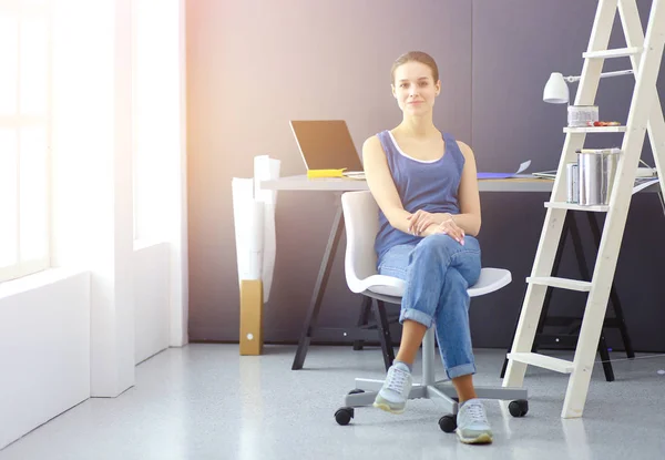 Ung kvinna sitter på skrivbordet på kontoret — Stockfoto