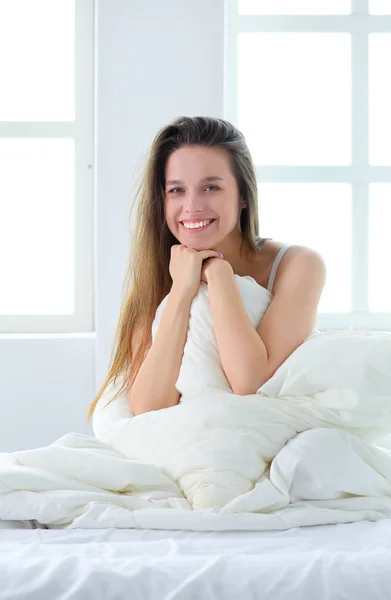 Pretty woman lying down on her bed at home — Stock Photo, Image