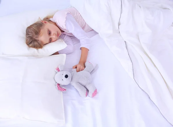 Niño niña duerme en la cama con un osito de peluche de juguete . — Foto de Stock