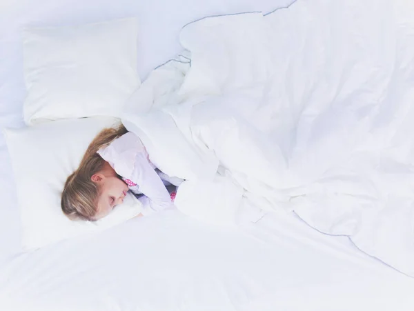 Дитяча дівчинка спить у ліжку з іграшковим плюшевим ведмедем . — стокове фото
