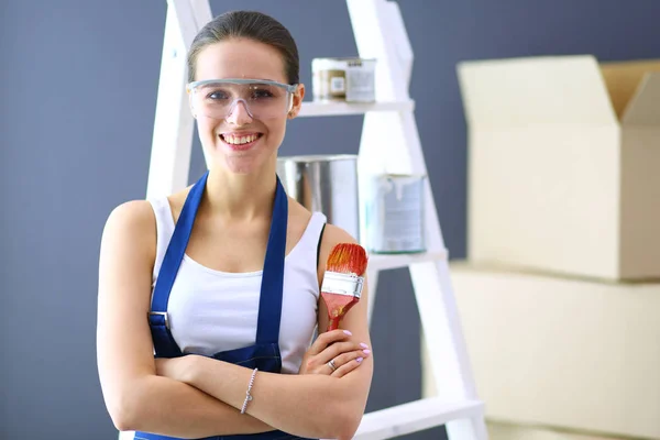 Feliz bela jovem fazendo pintura de parede — Fotografia de Stock