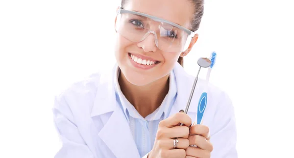 Bela dentista feminina segurando e mostrando uma escova de dentes isolada em um fundo branco. Médico dentista — Fotografia de Stock