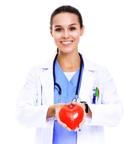 Positive female doctor standing with stethoscope and red heart symbol isolated. Woman doctor — Stock Photo, Image