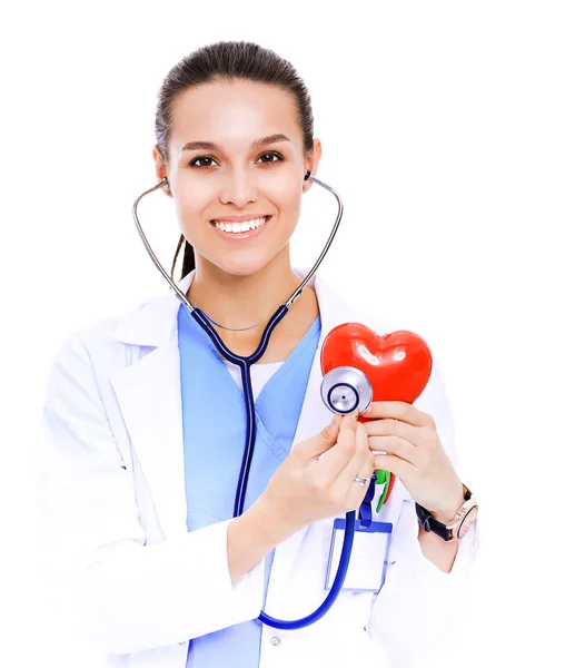 Positiva kvinnliga läkare står med stetoskop och red heart-symbolen isolerade. Kvinna läkare — Stockfoto