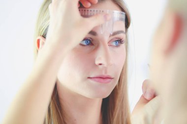 Kaşlar için kalıcı makyaj. Güzellik salonunda kalın kaşlı güzel bir kadın..