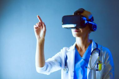 Sanal gerçeklik gözlüğü takan kadın doktor beyaz arka planda izole edilmiş..