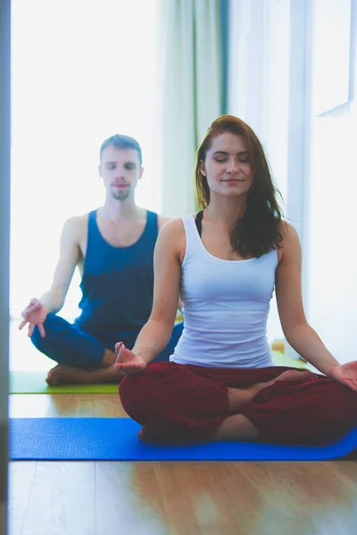 年轻健康的夫妇，在白色背景上的瑜伽位置 — 图库照片