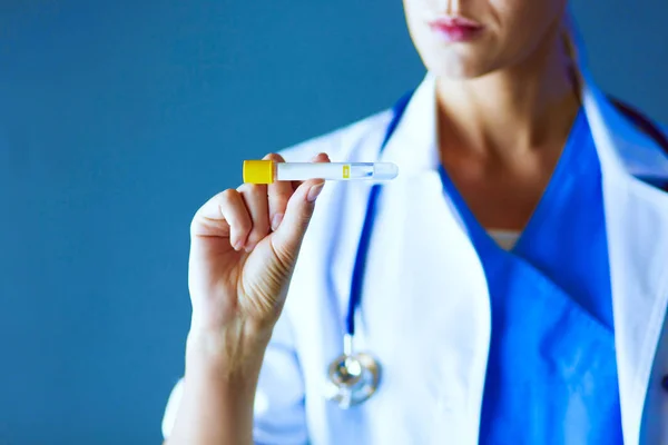 Femmina medico o ricercatore o medico utilizzando guardando una provetta di soluzione limpida in un laboratorio o laboratorio . — Foto Stock