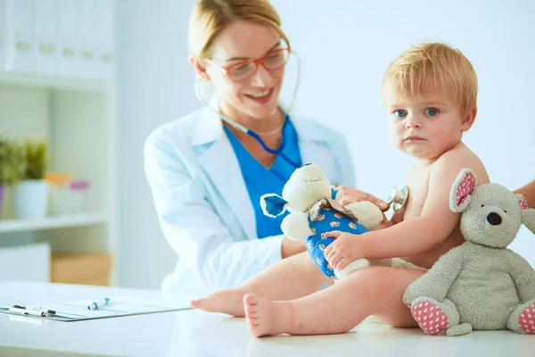 Female doctor is listening kid with a stethoscope in clinic — Stock Photo, Image