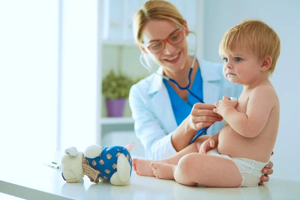 Ženský doktor poslouchá dítě se stetoskopem na klinice — Stock fotografie