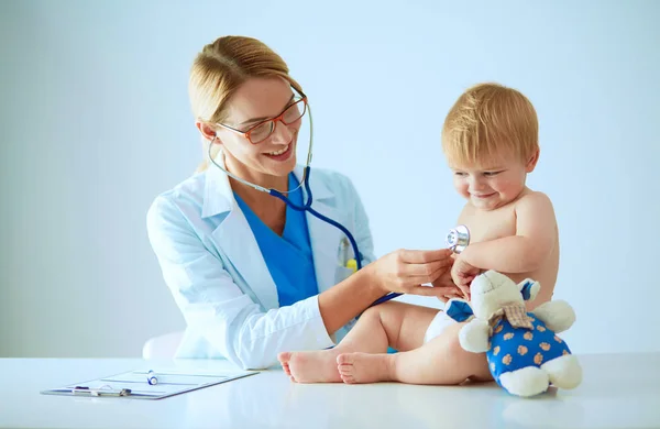 Vrouwelijke arts luistert kind met een stethoscoop in de kliniek — Stockfoto