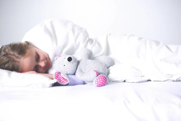 Малышка спит в кровати с игрушечным плюшевым мишкой . — стоковое фото